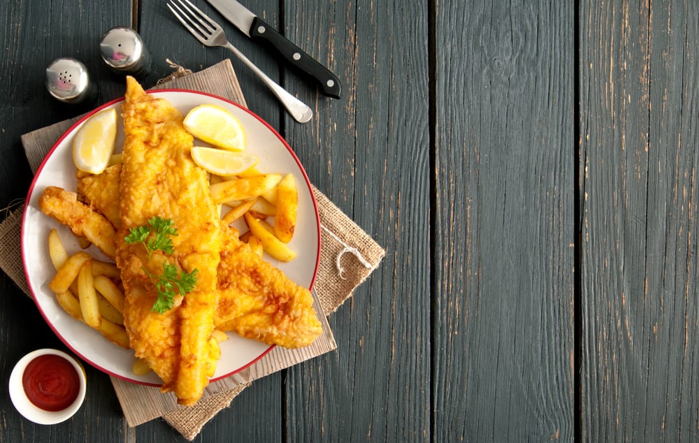 Fish and chips on wooden table.
