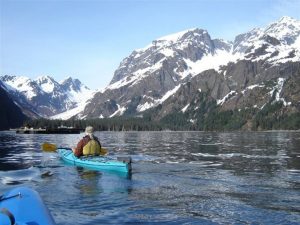 Photo of a Kayaker near a Glacier. Click Here to Learn More about our Fly Fishing Gifts.