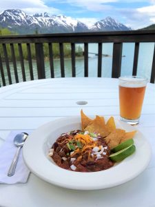 Chili and a beer on a balcony table.