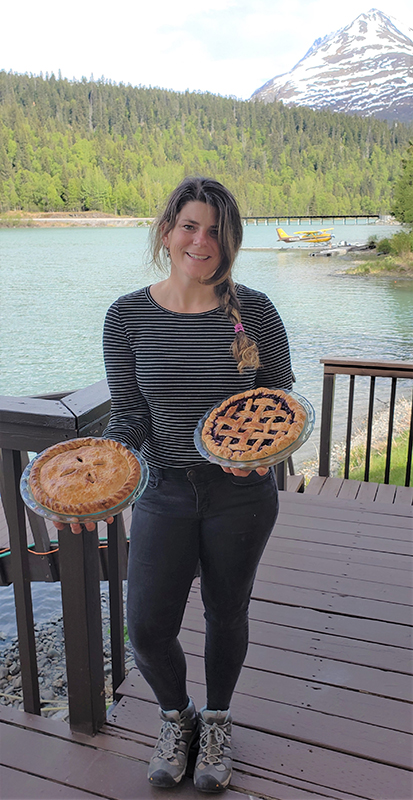 Woman holding two pies.